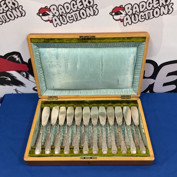 Vintage silver plate fish knife and fork set displayed in its case.