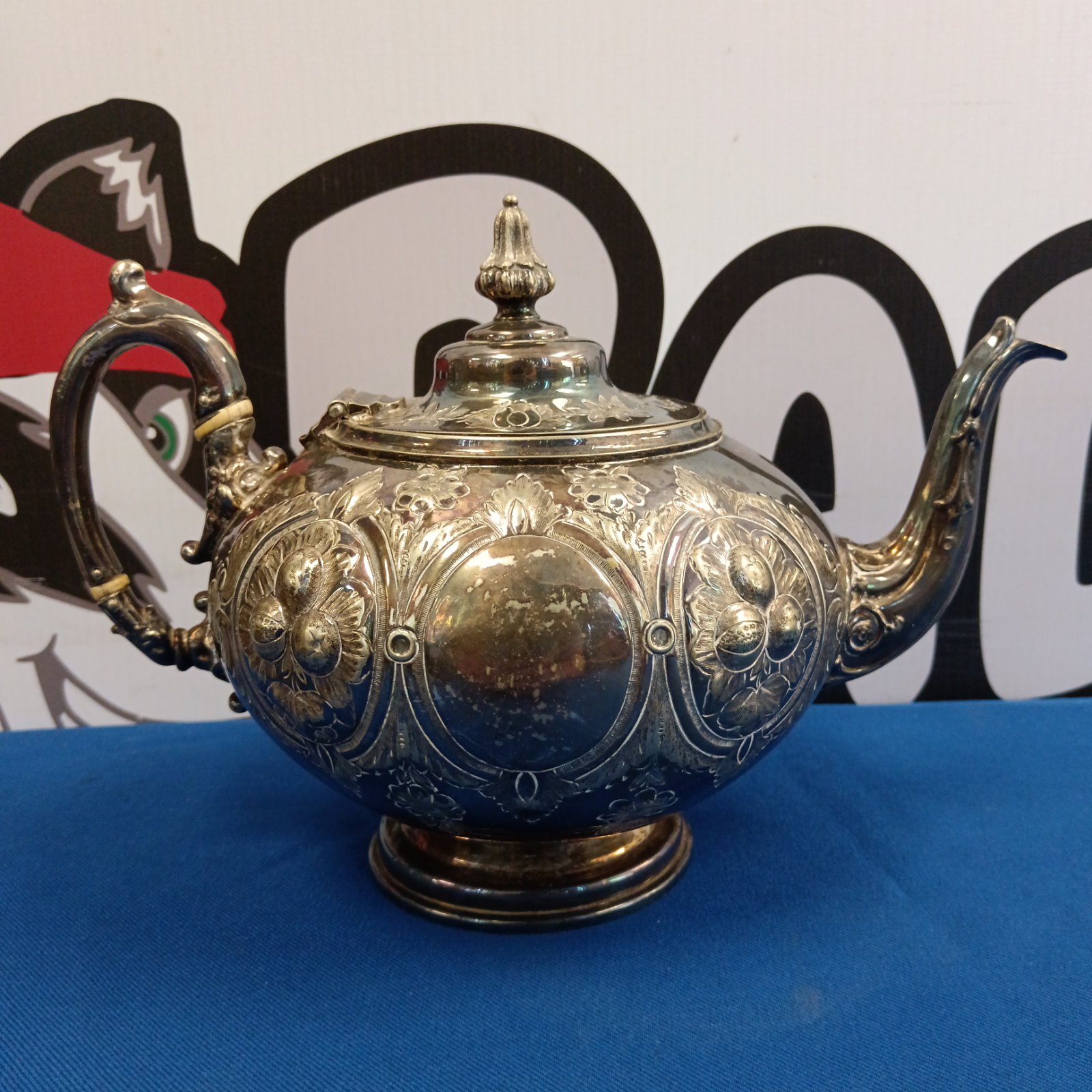 Intricate silver plated Victorian teapot with floral details.