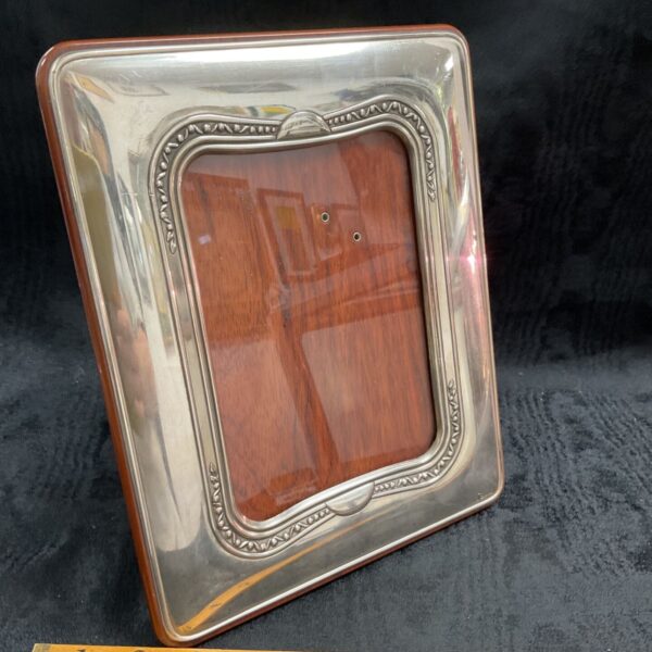 Ornate silver Sagui photograph frame with a wooden backing.