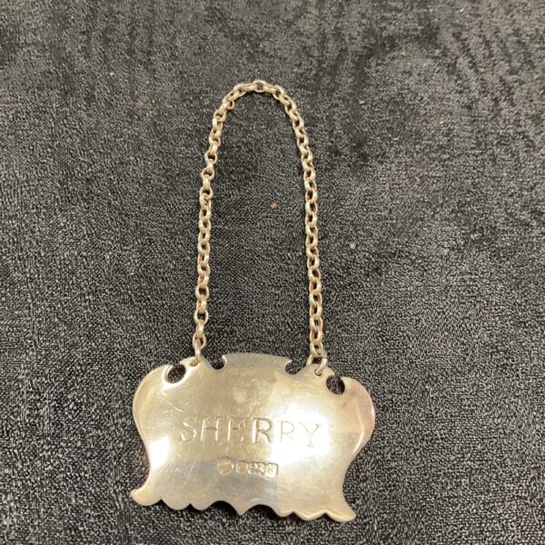Hallmarked silver sherry label with shaped outline.