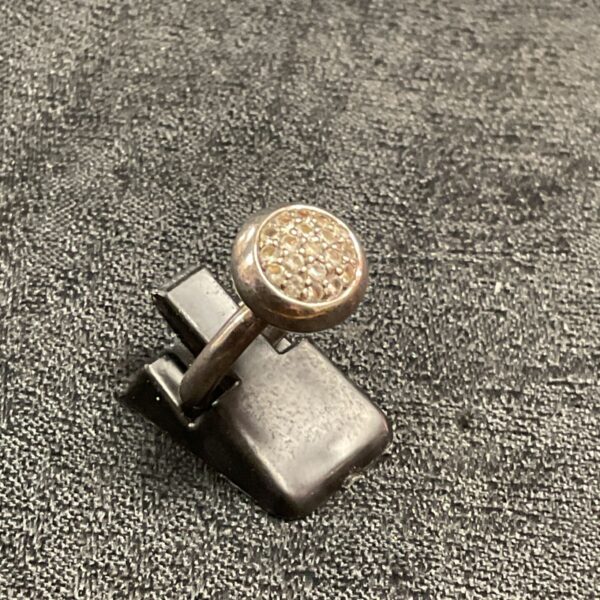 Close-up of silver ring with white stone cluster.