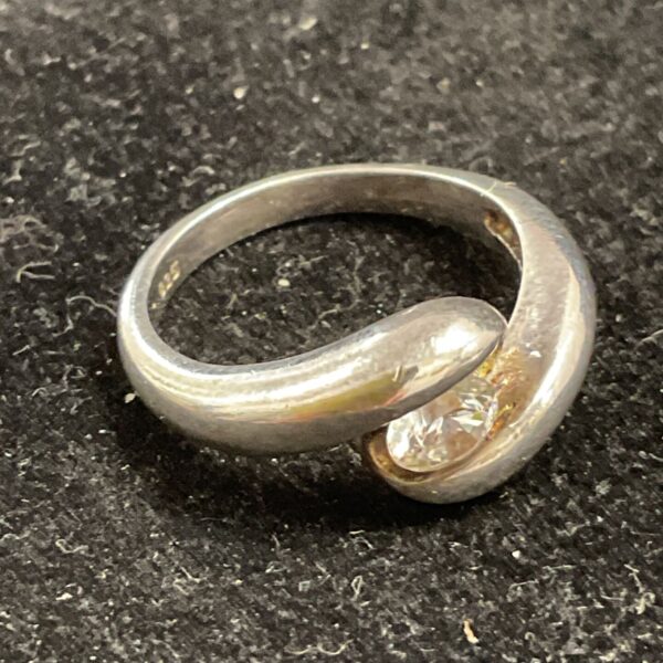Close-up of a silver ring with a white stone, size L.