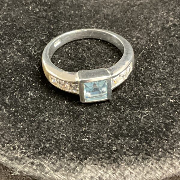 Silver ring with sky-blue topaz and cubic zirconia accents.