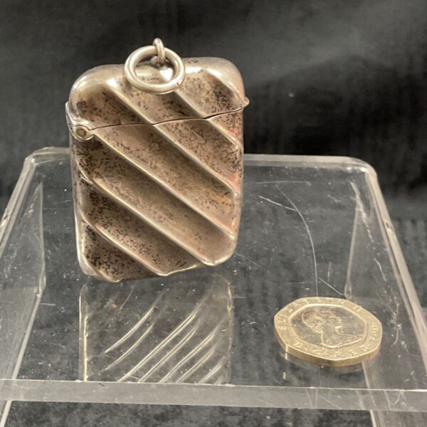 Antique silver vesta case with textured design and hallmarked silver.