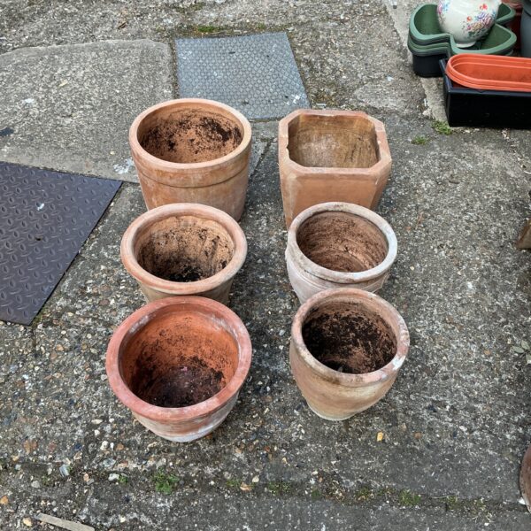 Six weathered terracotta planters for garden use.