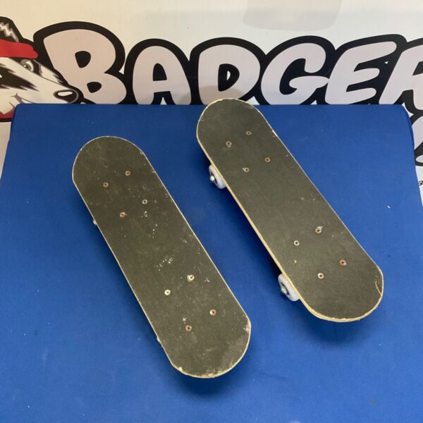 Two Skate Yo mini skateboards on a blue surface.