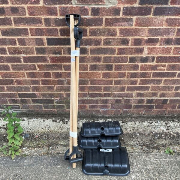 Lot of three yellow plastic snow shovels with wooden handles.