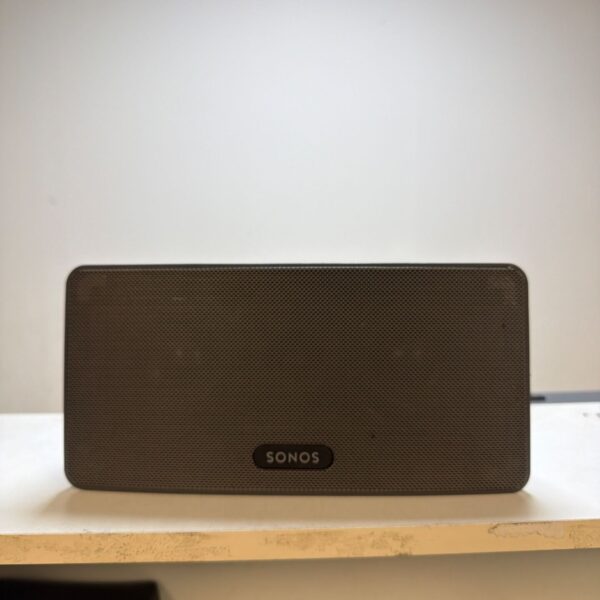 Black Sonos PLAY:3 wireless smart speaker on a shelf.