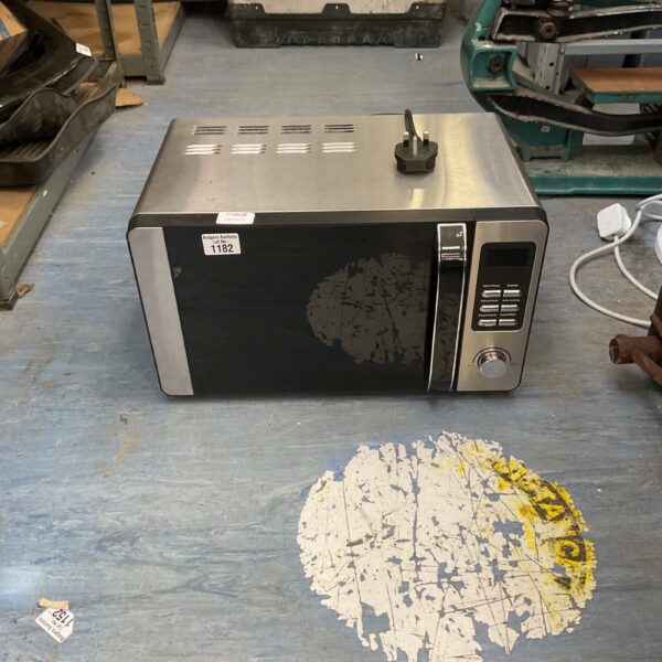 Stainless steel digital microwave oven on a workbench.