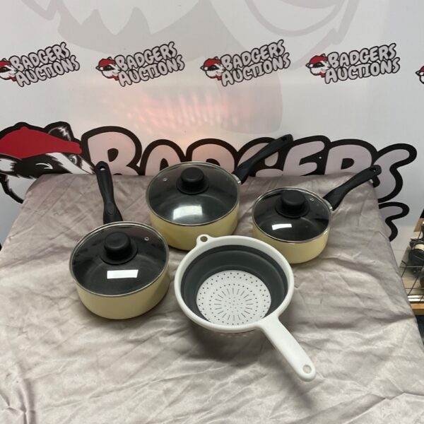 Stainless steel cooking pot set with white handles and lids.