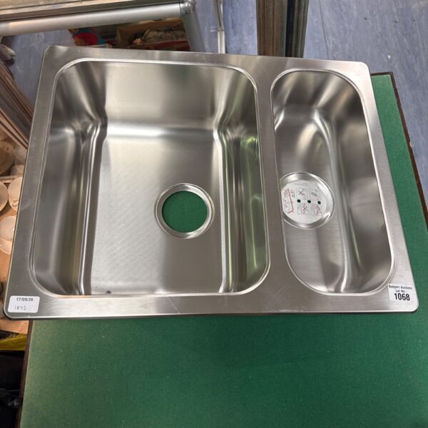 Stainless steel one and a half bowl sink basin with drain opening.