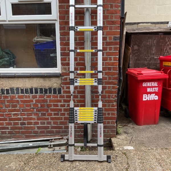 Used Stepomax telescopic ladder leaning against a wall.