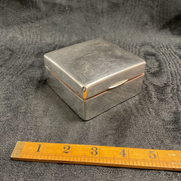 Vintage sterling silver cigarette box with ruler for scale.