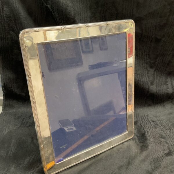 Ornate sterling silver photo frame with reflection of room.