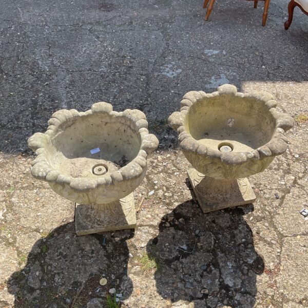 Pair of weathered stone effect planters for garden display.