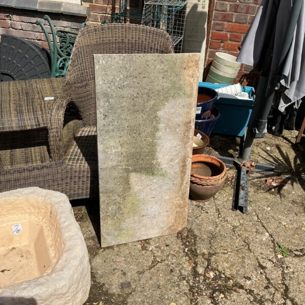 Rustic stone table top in a garden setting.