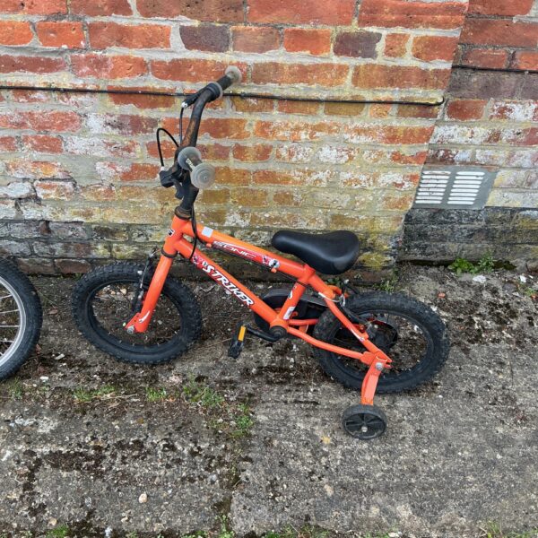Red Striker Sonic child’s bike with stabilisers for young riders.
