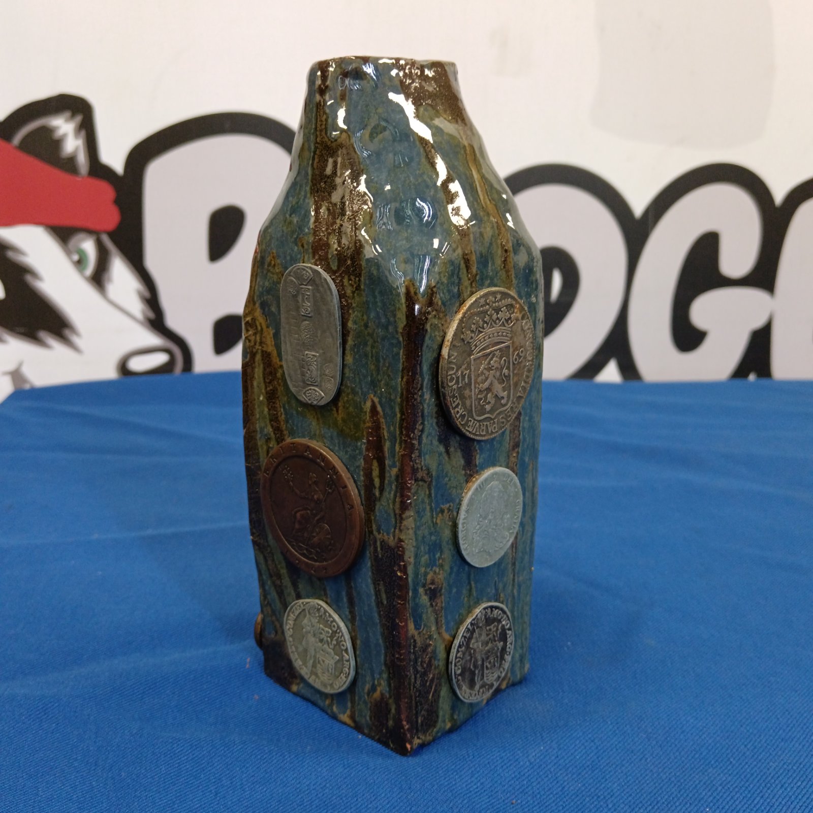 Studio pottery vase with coins embedded in the ceramic.