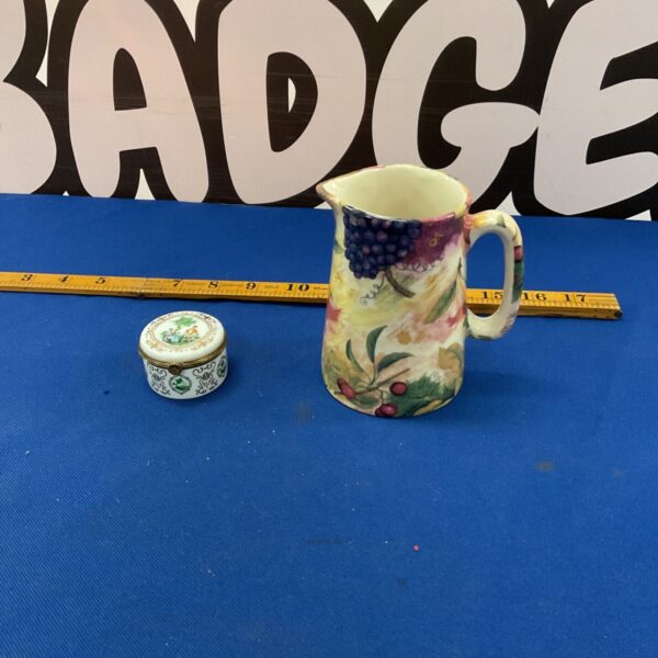 Colourful studio pottery jug with vibrant floral design.