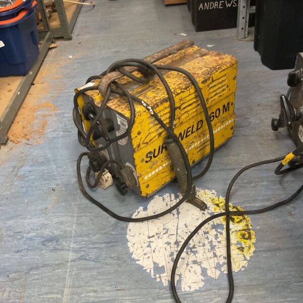 Vintage Sureweld 160M arc welder with attached cables.