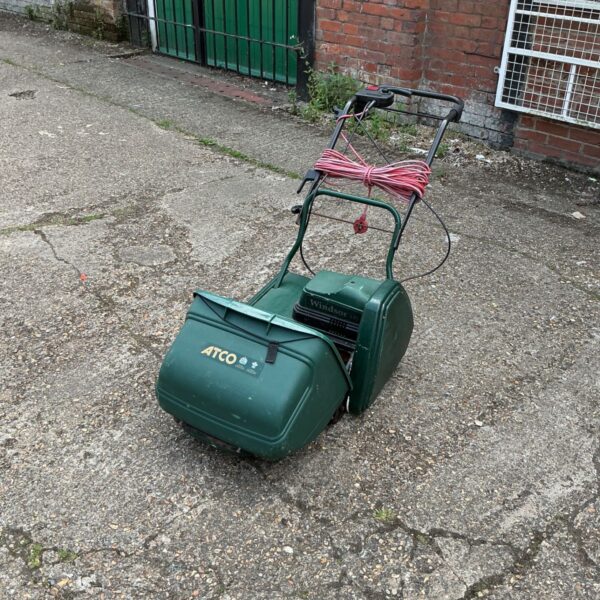Vintage Taco electric lawnmower in a garden setting.