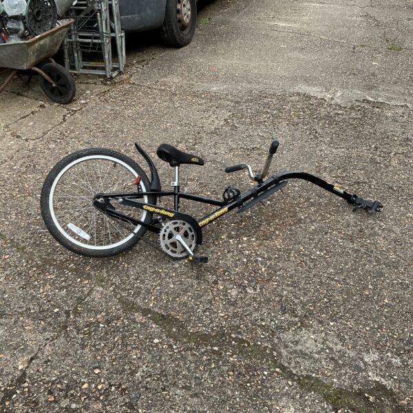 Vintage tag-along bike trailer for children, showing wear.