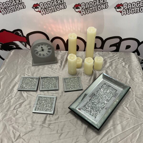 Sparkling tea serving set with electric candles and clock on a mirrored tray.