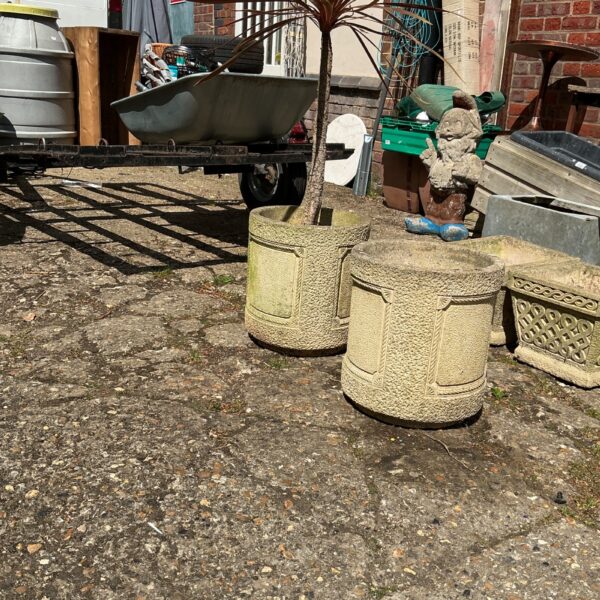 Two round terracotta garden planters with a small tree.