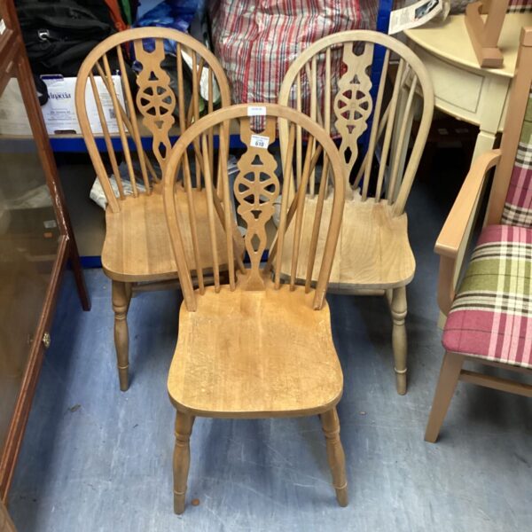 Vintage wheelback dining chairs in a rustic kitchen setting.