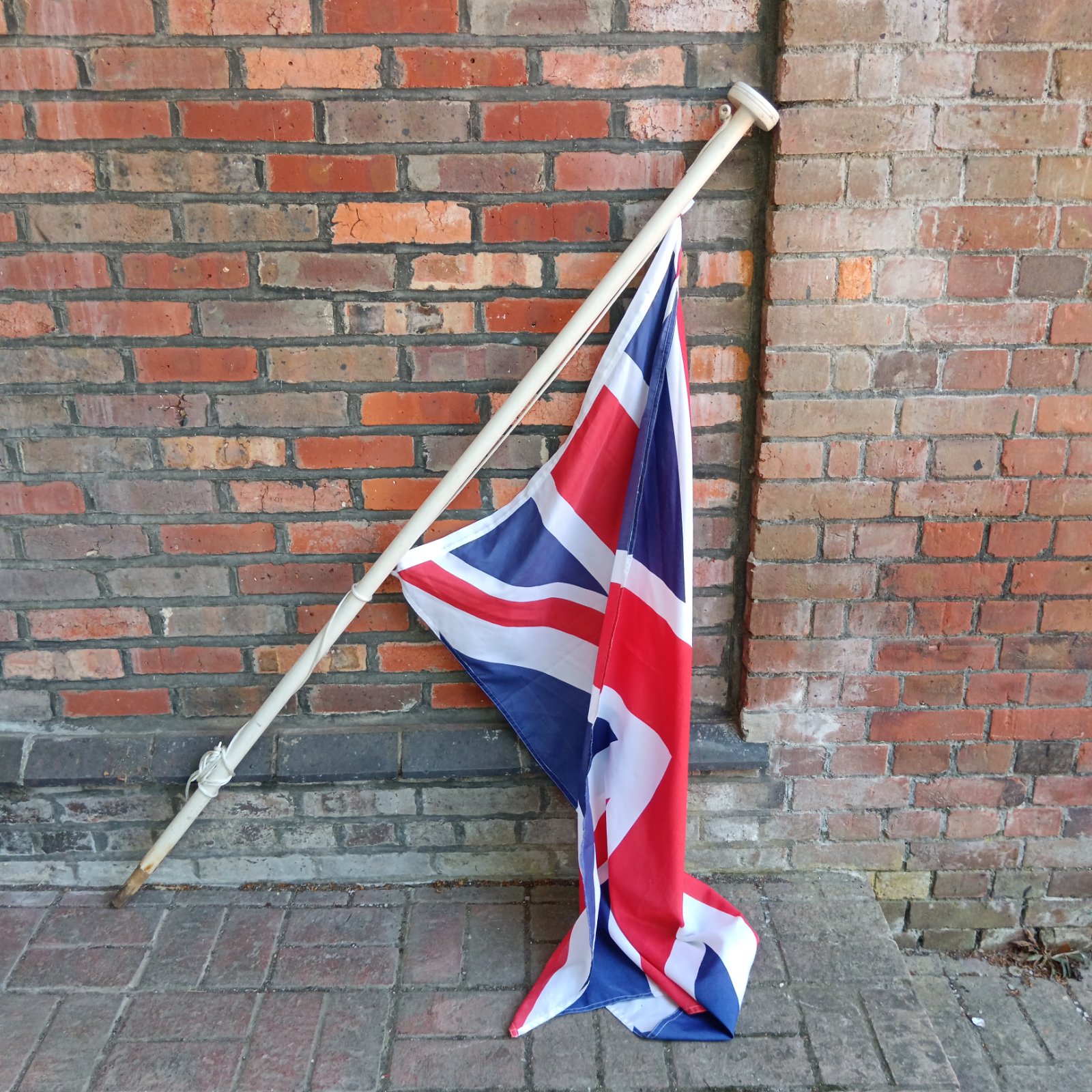 Vintage Union Flag on wooden flagpole, patriotic British decor.