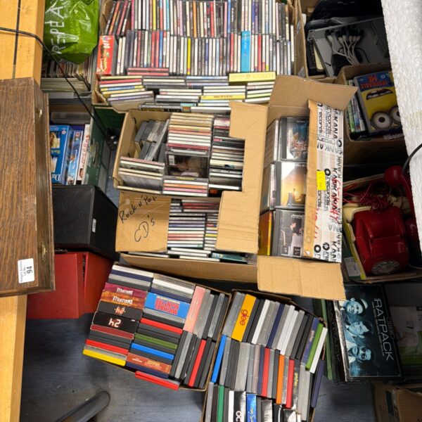 Large lot of VHS and DVD movies in cardboard boxes.