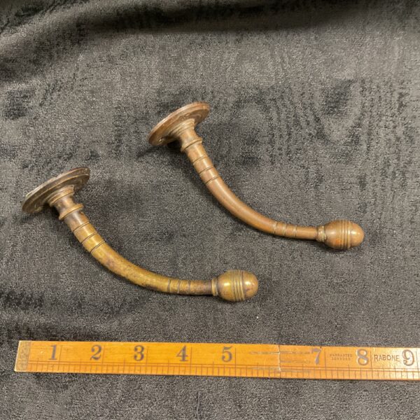 Pair of antique Victorian bronze coat hooks for hallway decor.