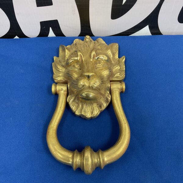 Antique Victorian brass lion door knocker with intricate details.