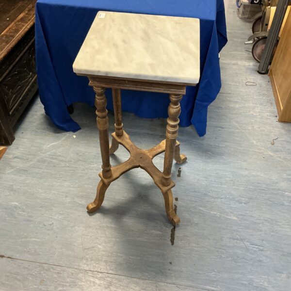 Antique Victorian washstand with a marble top and carved wooden legs.