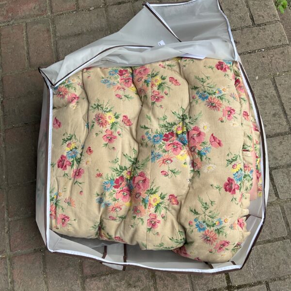Vintage 1950s floral double bed duvet, pale background.