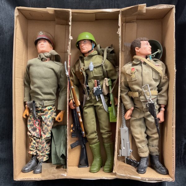 Group of three vintage Action Man figures in military uniforms.