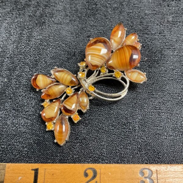 Vintage agate floral brooch with amber stones, close-up view.