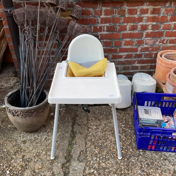 Vintage plastic baby highchair with a white frame and yellow seat.