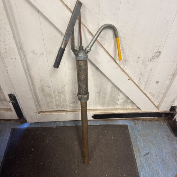 Vintage barrel pump with lever handle and aged metal finish.