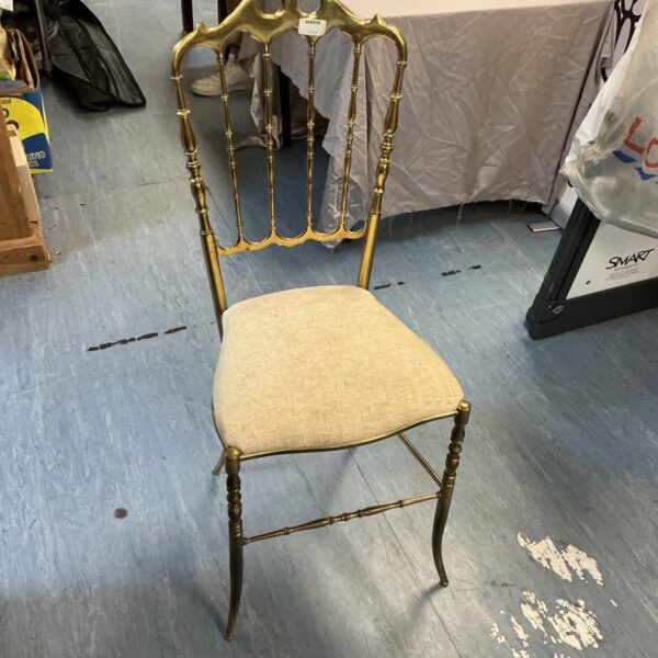 Ornate vintage brass bedroom chair with upholstered seat.