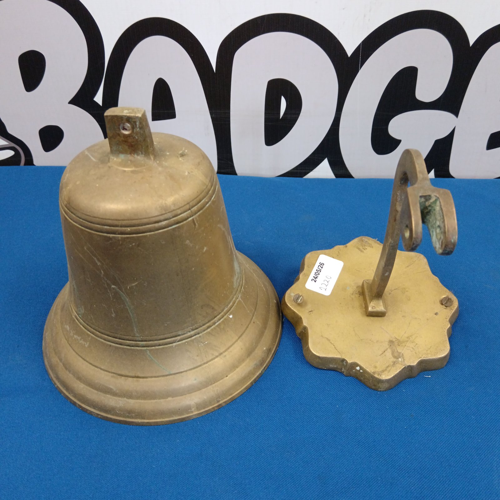 Vintage brass bell mounted on a wall bracket.