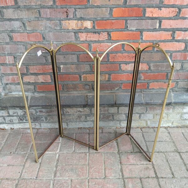 Vintage brass quad-fold fire screen for fireplace safety and decor.