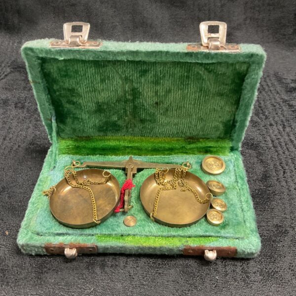 Vintage brass pocket balance scale in open case.