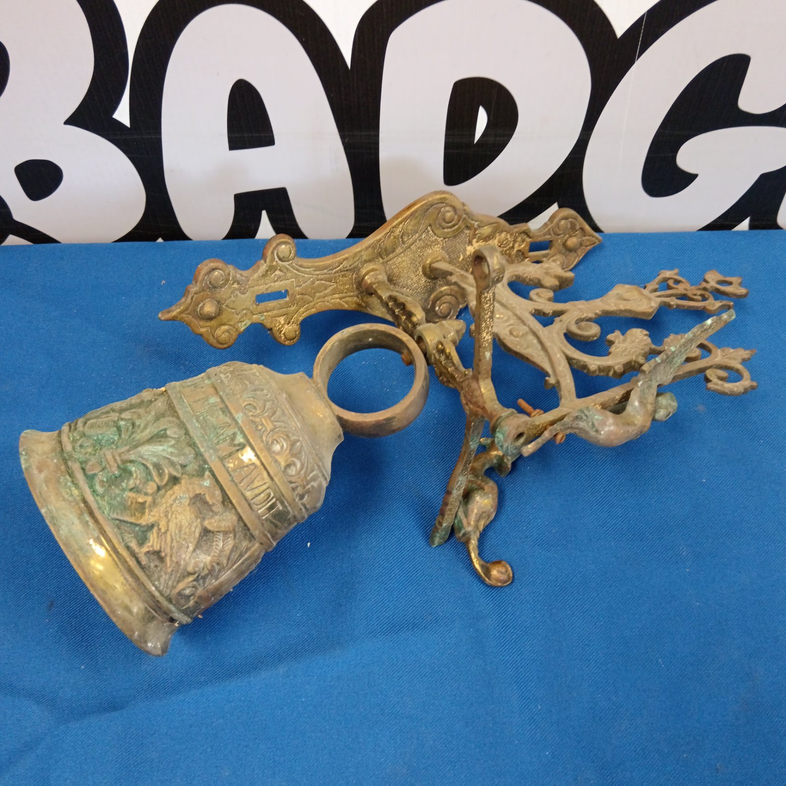 Vintage brass wall bell with floral details and bird design.
