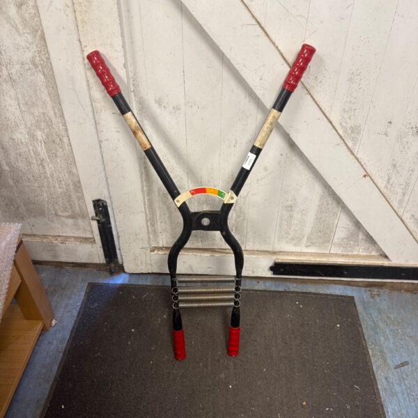 Vintage Bull Worker exercise machine with red handles.