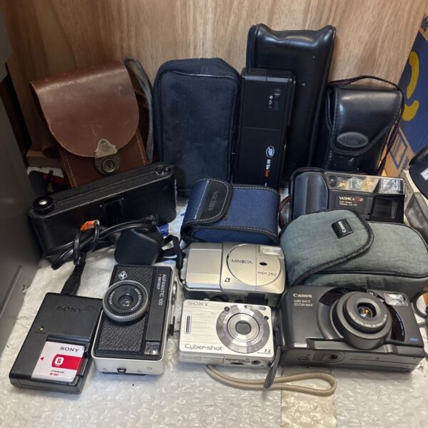 Vintage camera collection featuring Sony, Canon, and Minolta cameras with cases.
