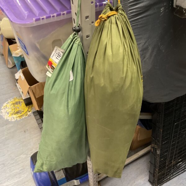 Vintage olive-green canvas camping tent, showing signs of wear.