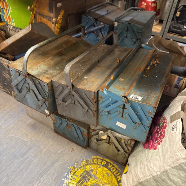 Six vintage metal cantilever toolboxes showing wear and rust.