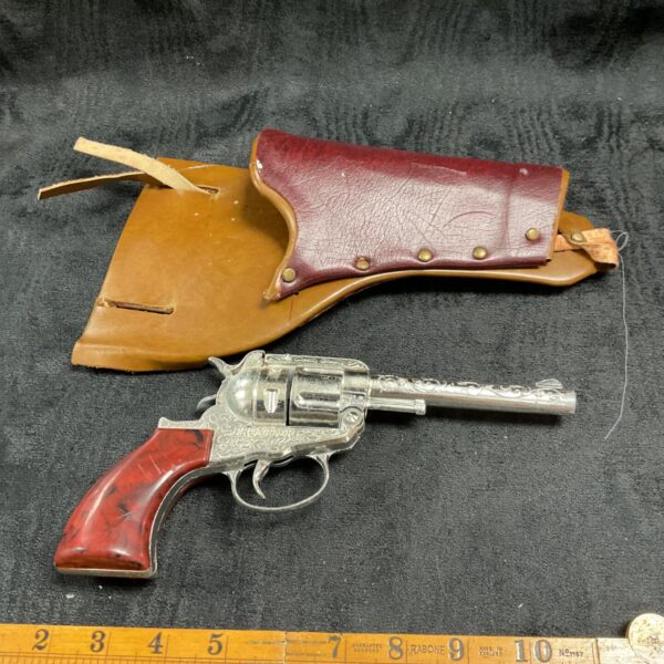 Vintage Frontier Ace cap gun with leather holster, collectible toy.