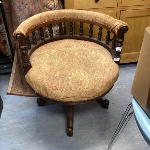 Vintage captain’s chair with patterned upholstery and wooden frame.